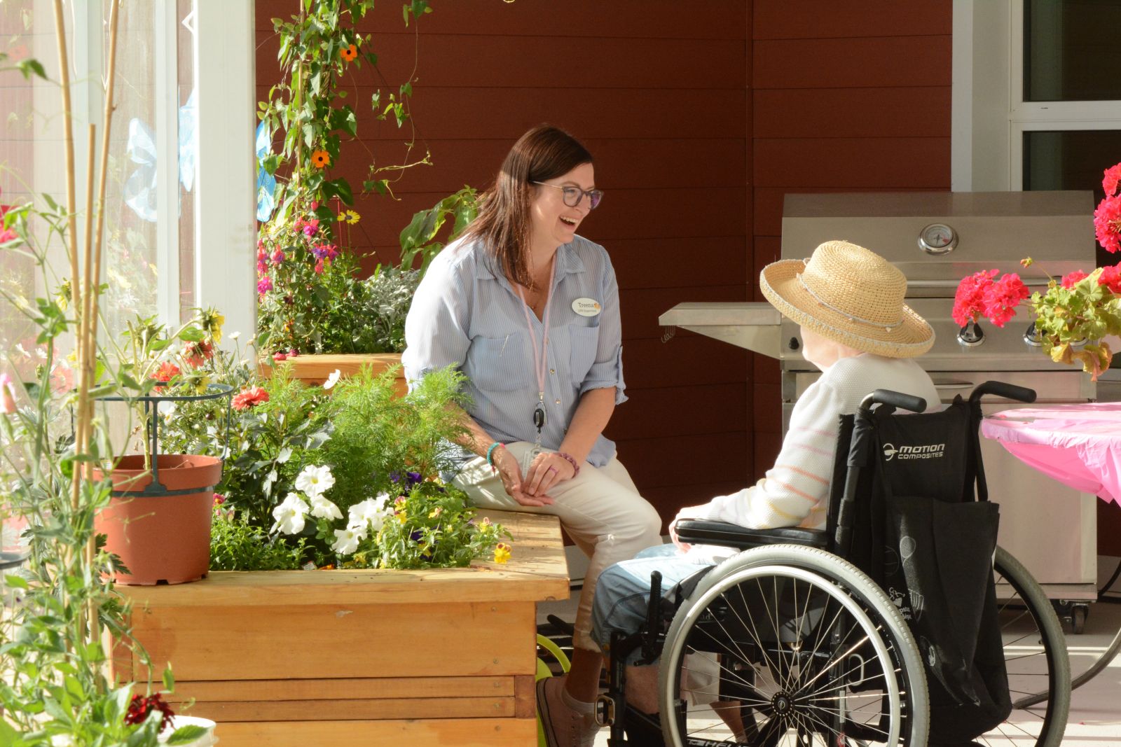 A conversation is shown between a health care worker and resident of Whistle Bend Place on a balcony