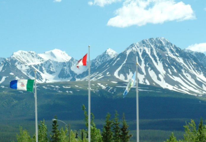 Flapoles stand in front of St. Elias mountains