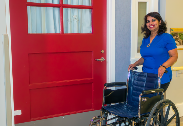 a person standing by a wheelchair. 