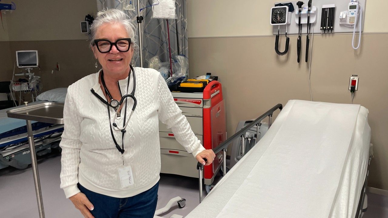 nurse standing by a patient's bed