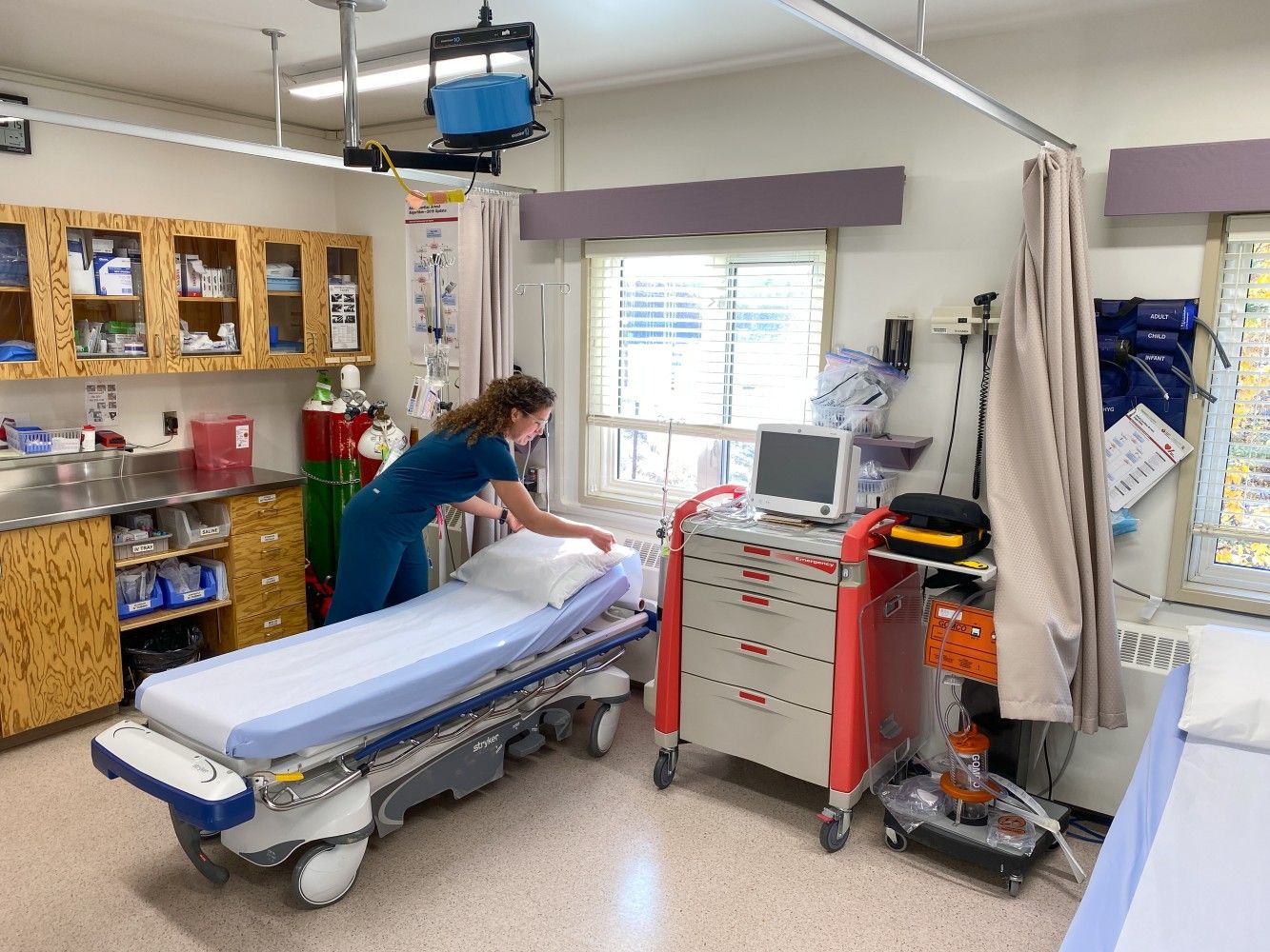 nurse standing by a patient's bed