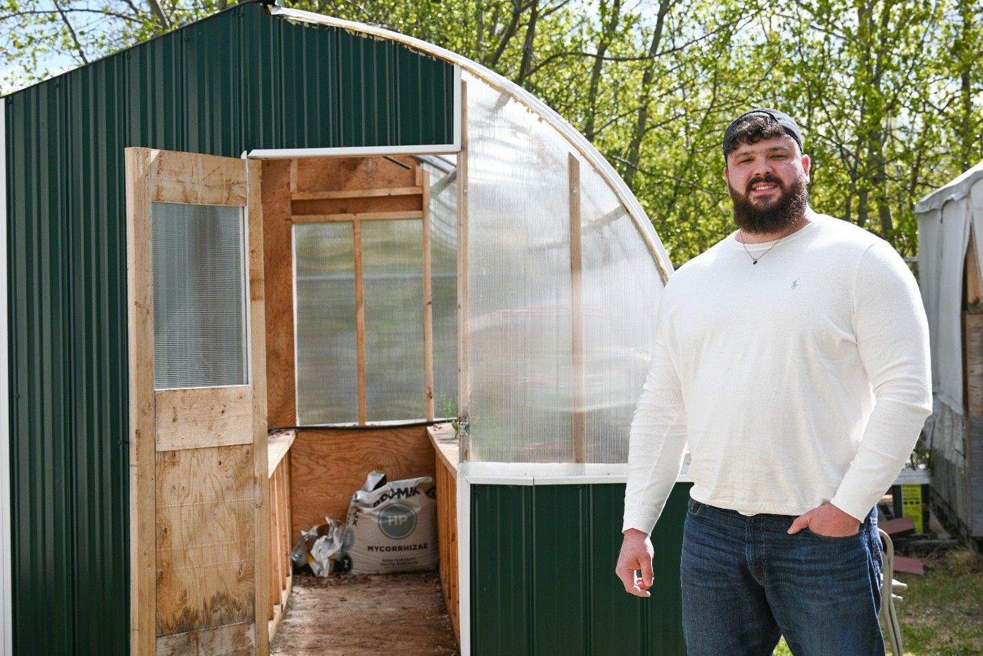 a person standing by a greenhouse