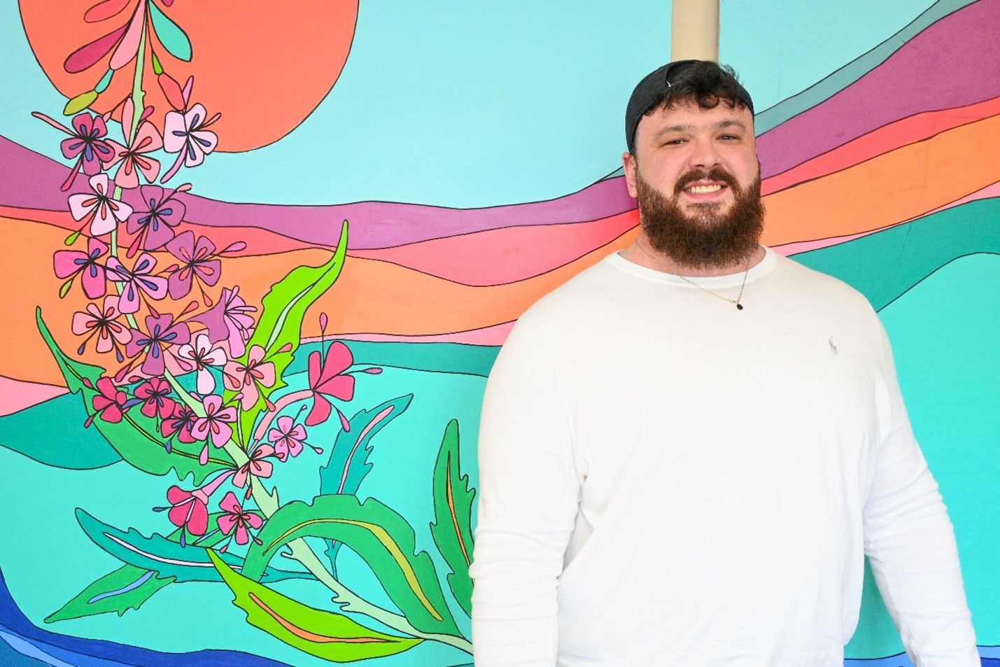 a person standing in front of a colourful drawing