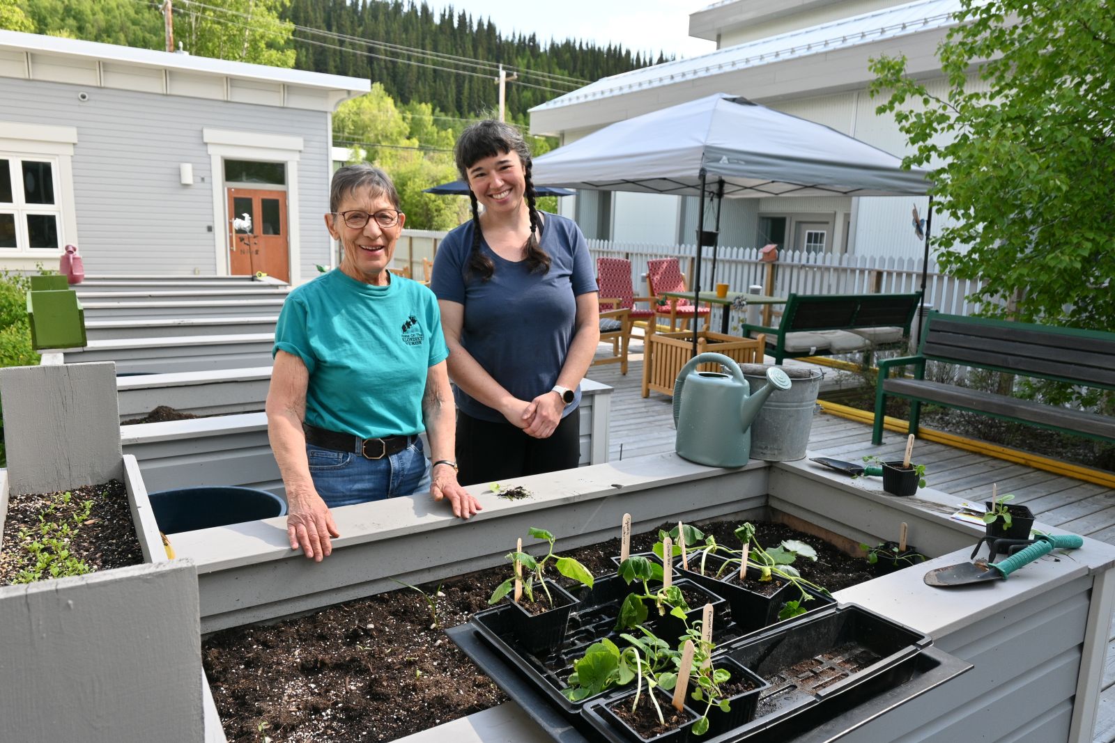 2 people standing by a raised garden bed