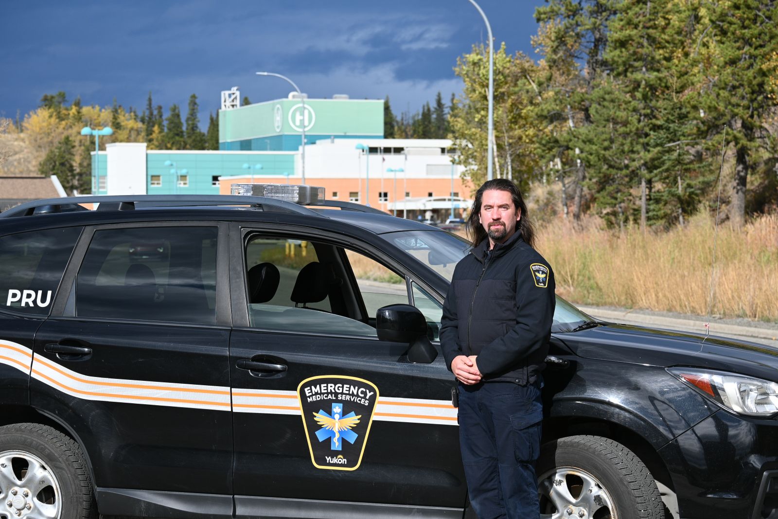 A paramedic specialist is shown with a Yukon EMS vehicle outside Whitehorse General Hospital