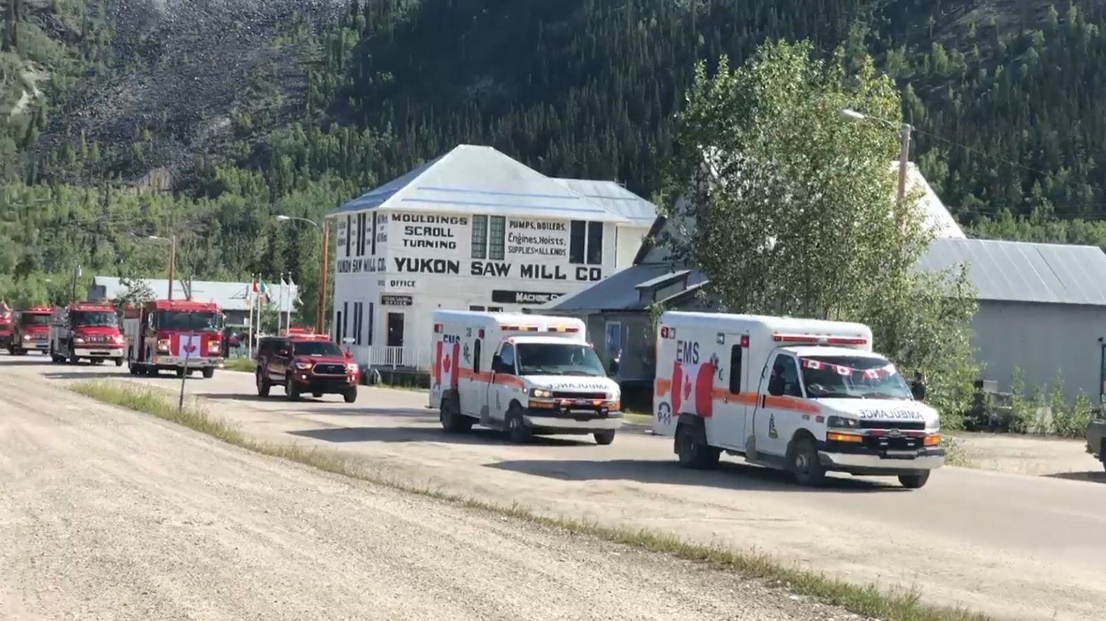 A Canada Day parade in Dawson City with Yukon EMS ambulances taking part