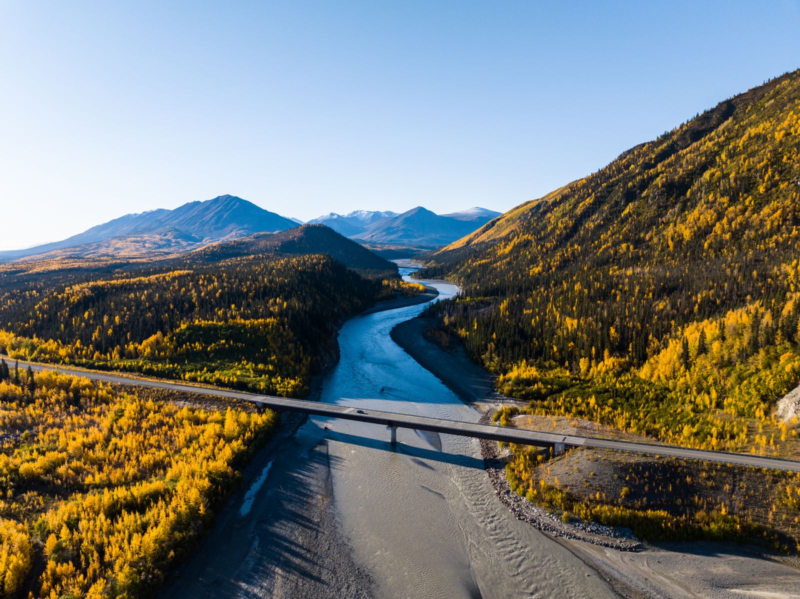 A vehicle crosses the Alaska Highway bridge over Beaver Creek as it drives westward toward the Canada-USA border and the small community of Beaver Creek.