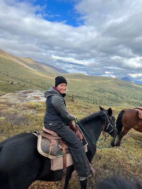 A cultural resource worker is shown on horseback enjoying the wild spaces and landscapes of the Yukon