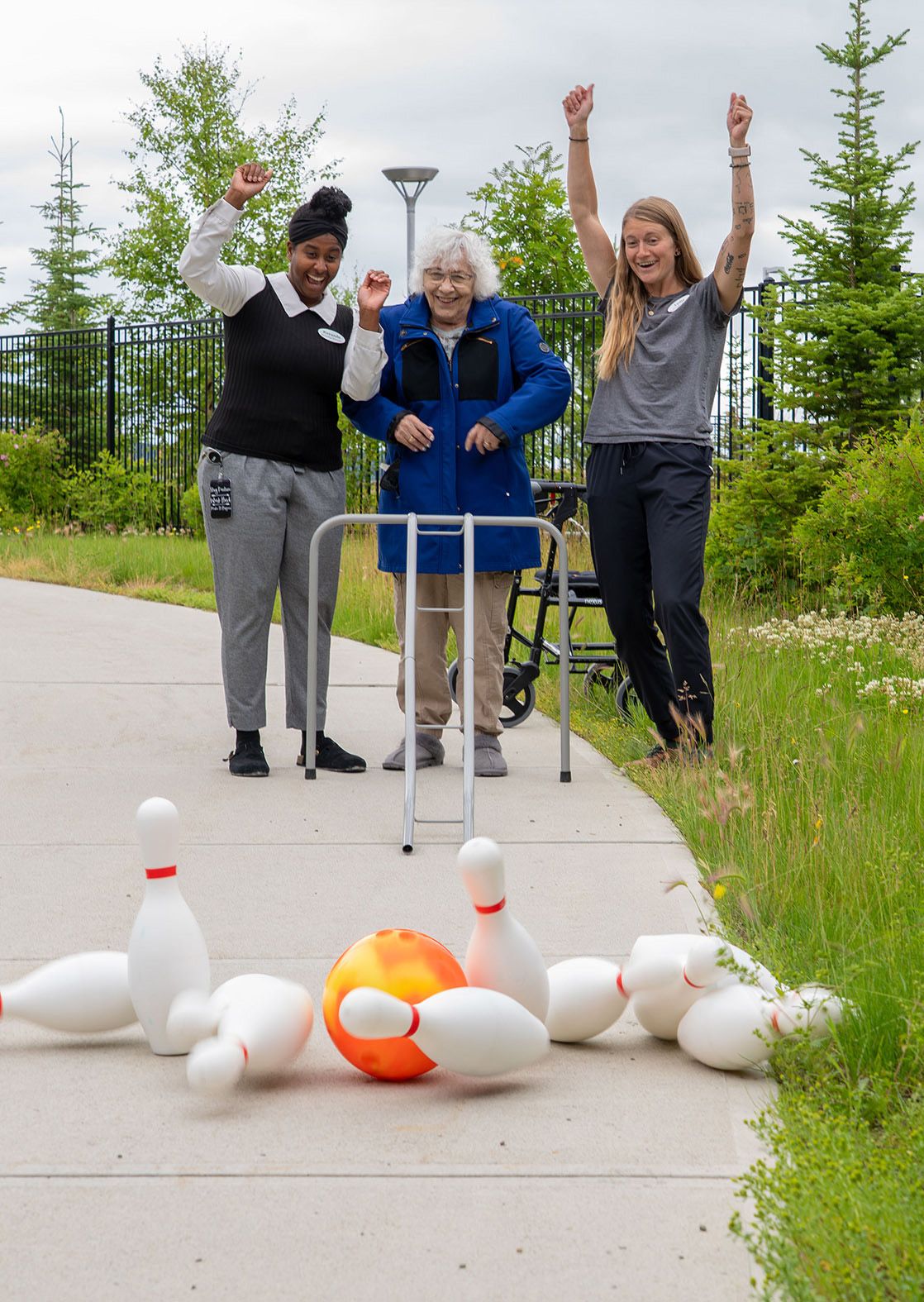 Lydia (right) and colleague Rayanda (left) celebrate during a game of bowling with Bernice who is a resident of Whistle Bend Place.