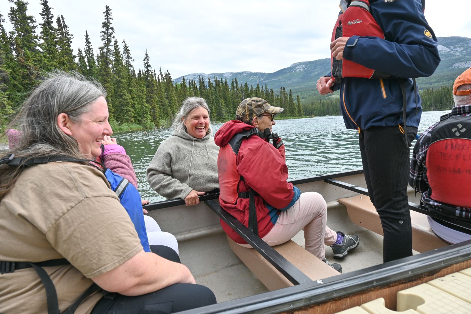 Sylvie (centre) in hip waders, helping residents safely enter a canoe.