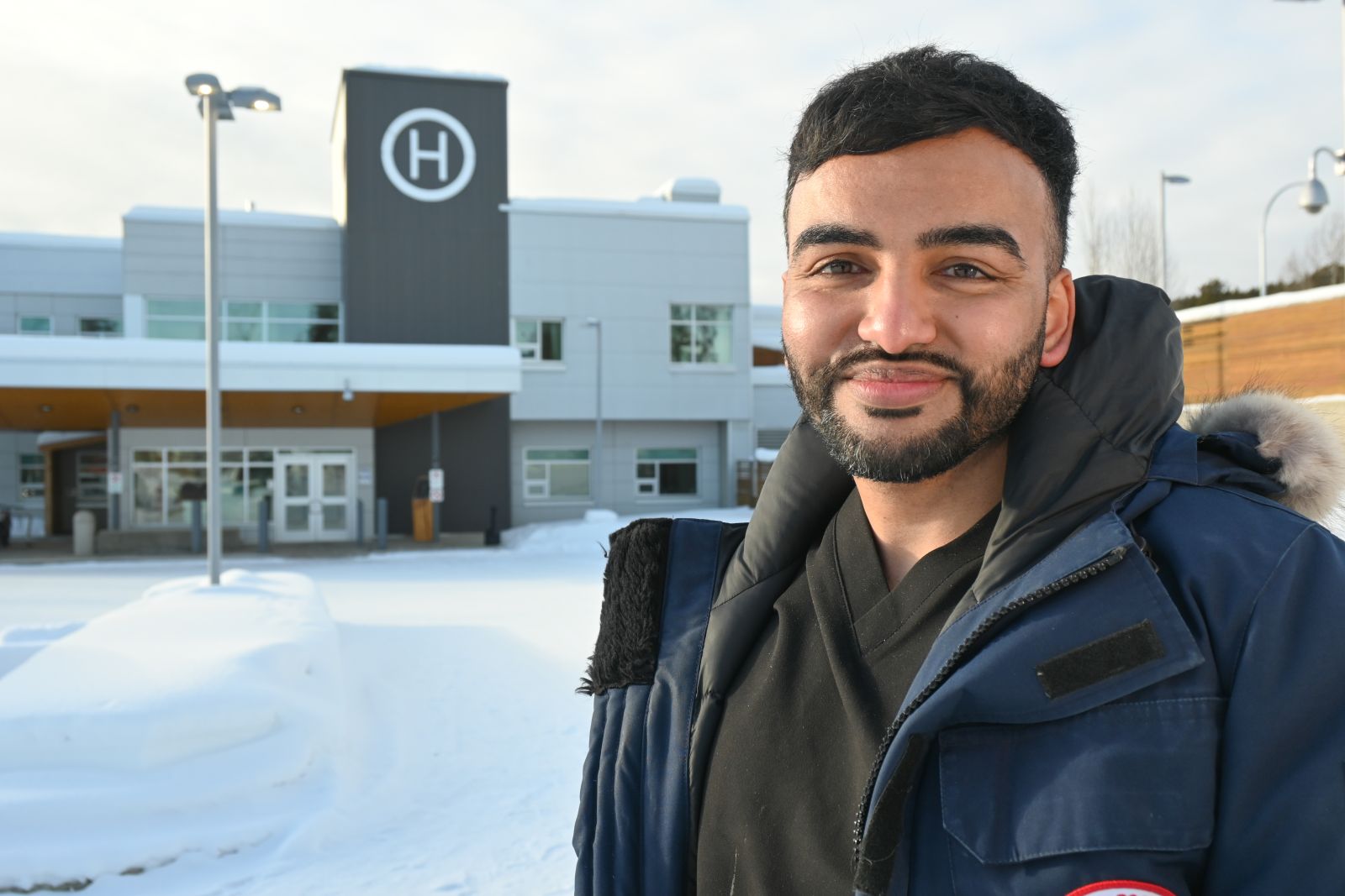 portrait of doctor standing outside hospital winter