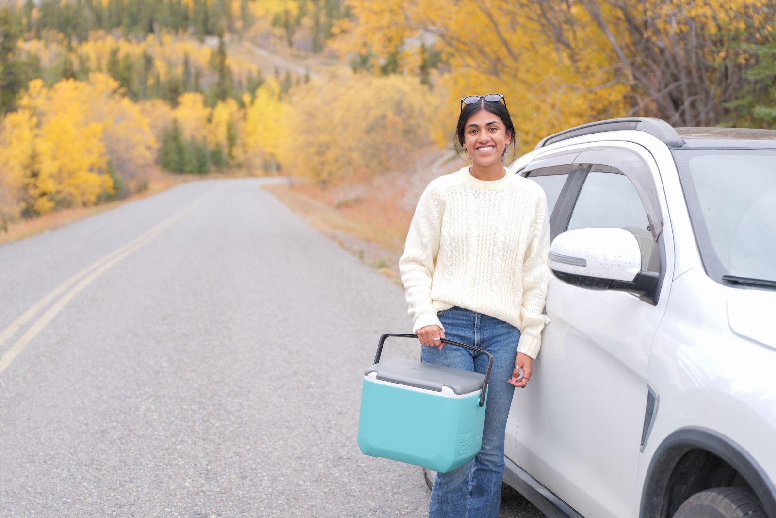 A home care nurse in the Yukon stands alongside her vehicle