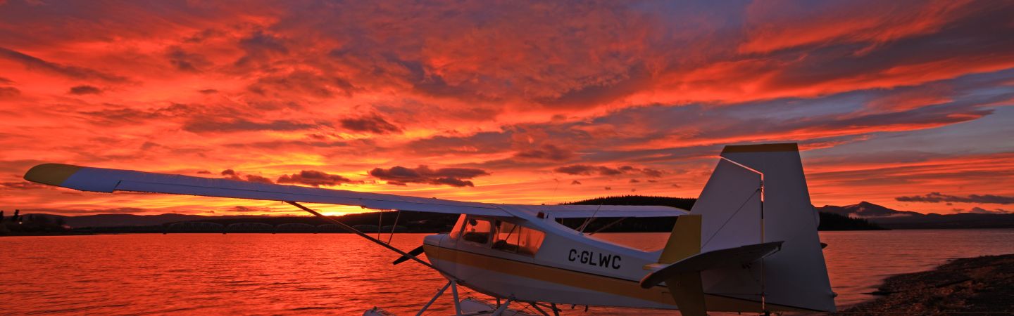 Floatplane on Teslin lake shore during sunset.