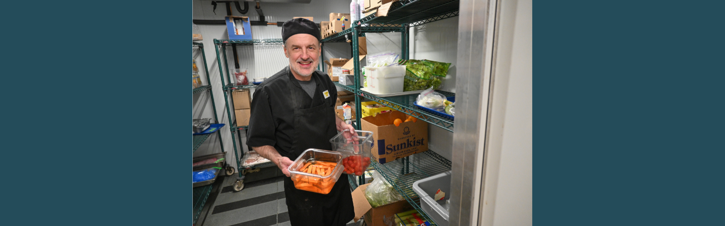A cook is seen in the kitchen at Alexander McDonald Lodge in Dawson City surrounded by fresh ingredients