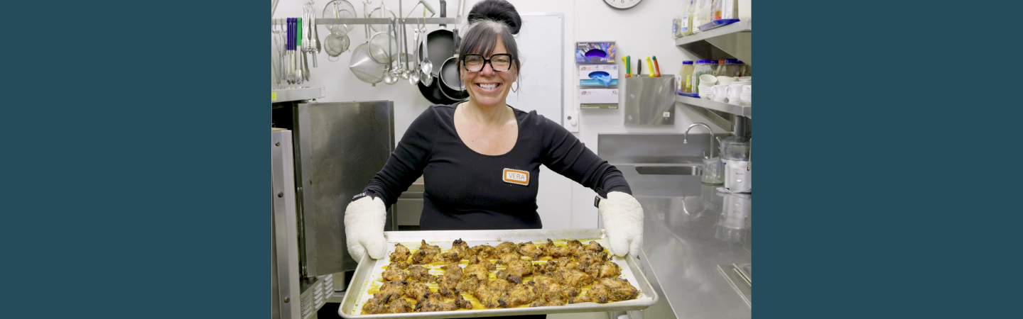 A staff member shows off a baking sheet in the kitchen of Alexander McDonald Lodge in Dawson City