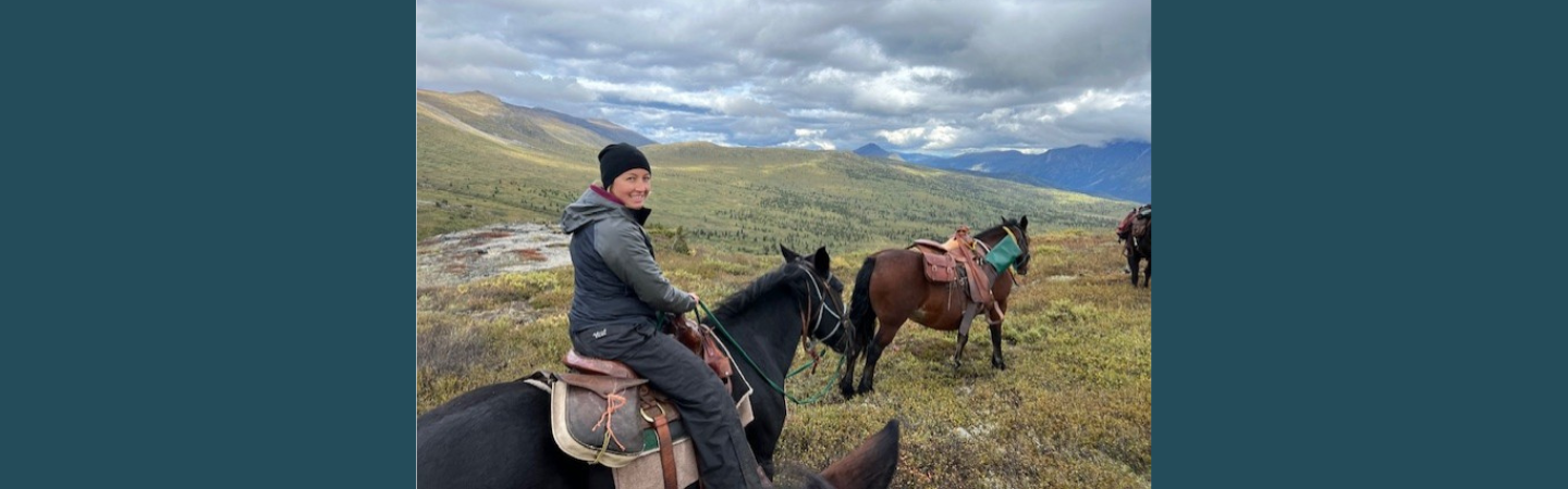 A cultural resource worker is shown on horseback enjoying the wild spaces and landscapes of the Yukon